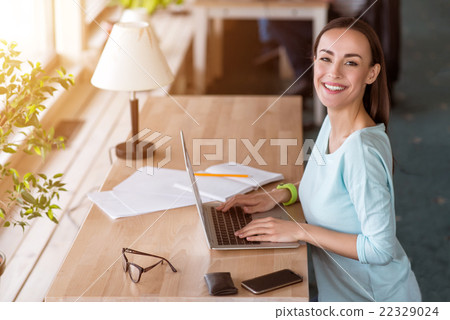 Positive woman using laptop  22329024