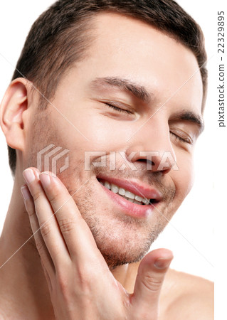 Cheerful unshaved guy is caring of skin 22329895