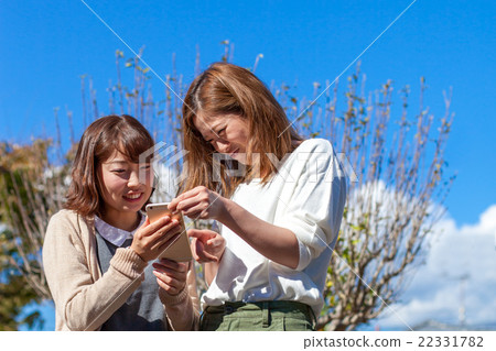 Two women in their twenties who have trouble watching the phone Two women in their twenties who have trouble watching the phone 22331782