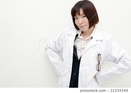 A lady in a white garment holding hands on her back A lady in a white garment holding hands on her back 22334349