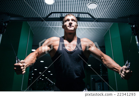 Strong bodybuilder doing chest exercise with cable 22341293