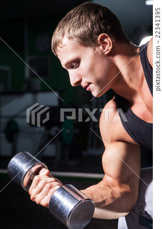 Close-up of young man doing concentration curls 22341395