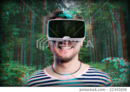 Man wearing virtual reality goggles. Green forest. 22345606