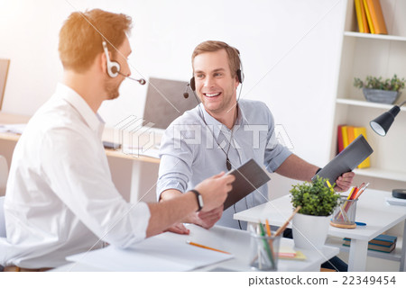Cheerful colleagues sitting at the table Cheerful colleagues sitting at the table 22349454