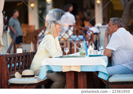 Middle-aged couple enjoying a meal and wine Middle-aged couple enjoying a meal and wine 22361950