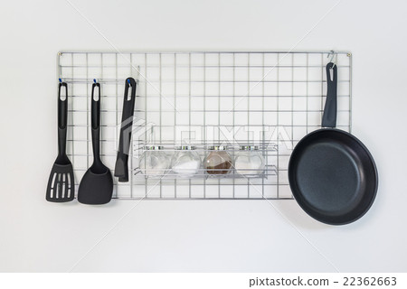 iron frying pan and utensils hanging on the wall 22362663