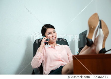 Relaxed business woman sitting in a chair with Relaxed business woman sitting in a chair with 22366417