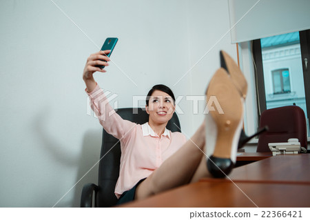 Relaxed business woman sitting in a chair with Relaxed business woman sitting in a chair with 22366421