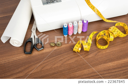 Sewing machine with many utensils on table 22367845