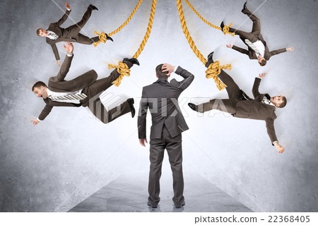 Confused businessman looking on hanging people Confused businessman looking on hanging people 22368405