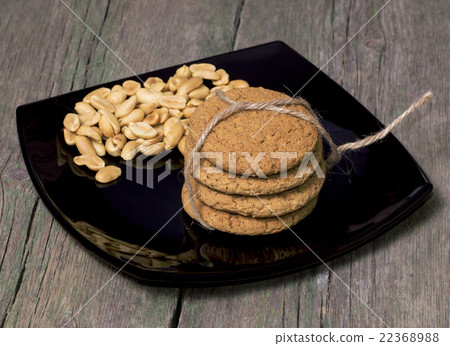 black plate with a peanut and oatmeal cookies 22368988