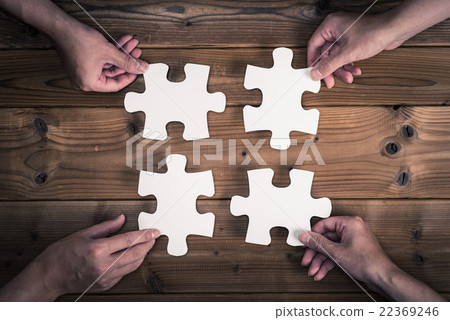 Human hand holding a piece of a jigsaw puzzle 22369246