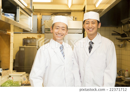 Two men wearing cookbooks Two men wearing cookbooks 22371712
