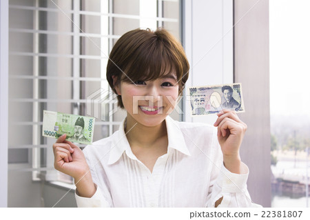 A young woman with a 10,000 won note and a thousand yen note A young woman with a 10,000 won note and a thousand yen note 22381807