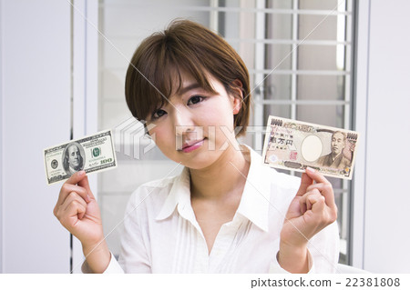 A young woman with 10,000 yen bill and 100 dollar bill 22381808