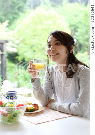 A woman who eats breakfast at the window side A woman who eats breakfast at the window side 22386641