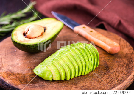 Sliced avocado with knife on cutting board Sliced avocado with knife on cutting board 22389724
