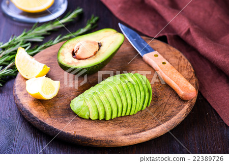 Sliced avocado with knife on cutting board Sliced avocado with knife on cutting board 22389726