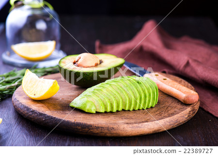 Sliced avocado with knife on cutting board 22389727