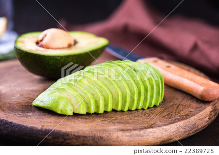 Sliced avocado with knife on cutting board 22389728