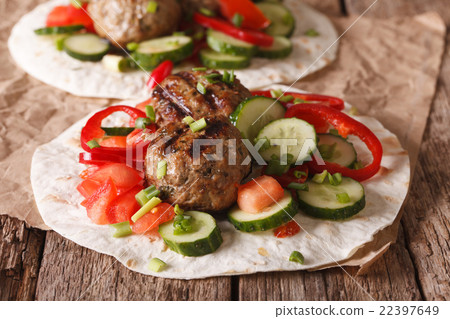 Grilled meat balls with vegetables on a flat bread 22397649