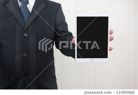 A man with a suit showing a tablet 22400980