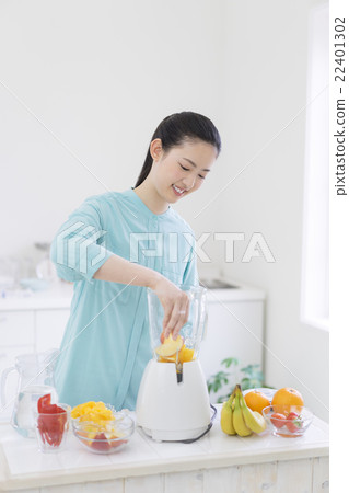 A Japanese woman standing in front of the mixer 22401302