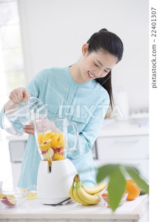 A Japanese woman standing in front of the mixer 22401307