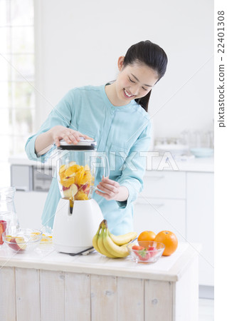 A Japanese woman standing in front of the mixer 22401308