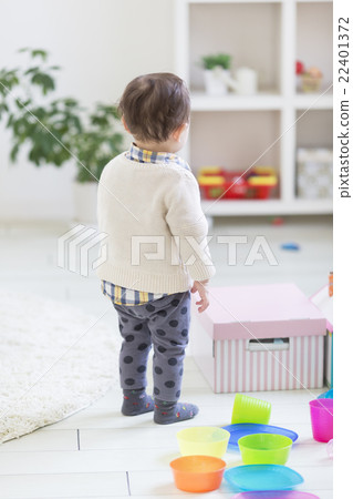 A boy standing in a child's room 22401372