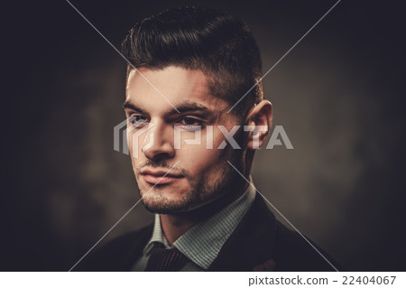 Serious well-dressed hispanic man posing in studio 22404067