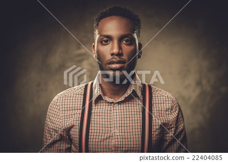 Stylish black man posing on dark background. 22404085
