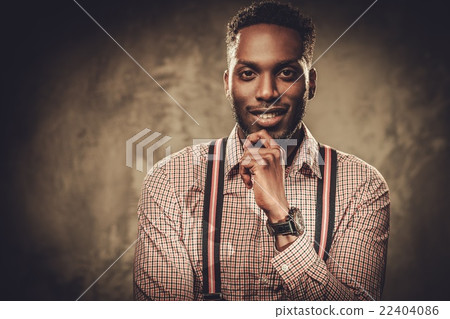 Stylish black man posing on dark background. Stylish black man posing on dark background. 22404086