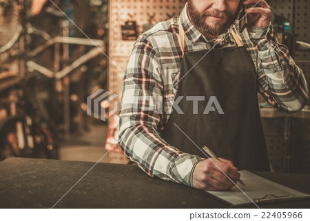 Bicycle mechanic doing his job in workshop. 22405966