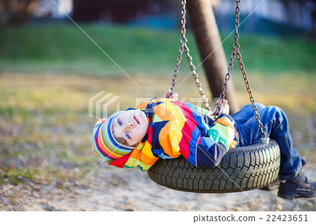 Little kid boy swinging on playground outdoors Little kid boy swinging on playground outdoors 22423651