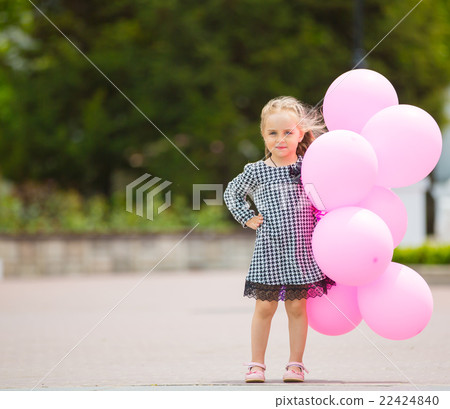 Little girl holding pink balloons Little girl holding pink balloons 22424840
