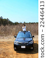 A female photographer holding a telephoto lens from the sunroof of SUV 22446413