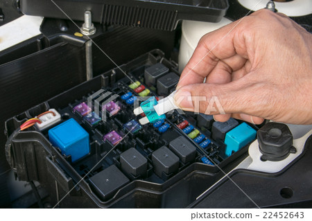 Auto mechanic checking a car fuse 22452643