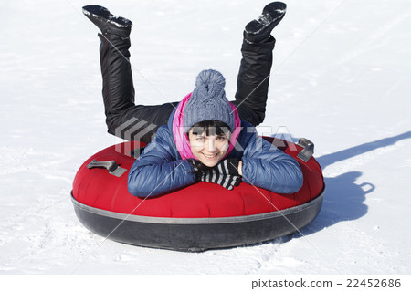 Young happy girl riding on snow tube Young happy girl riding on snow tube 22452686