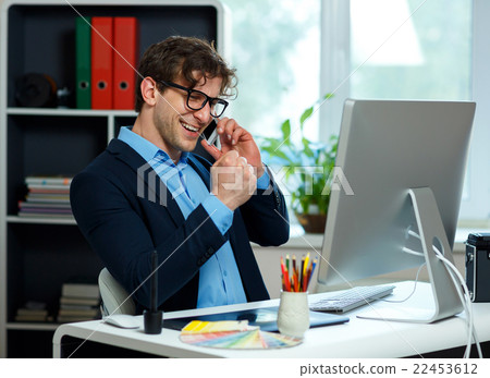 Handsome young man working from home office and using smartphone 22453612