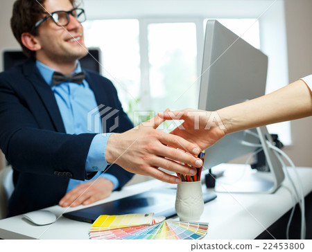 Businessman and businesswoman shaking hands in office 22453800