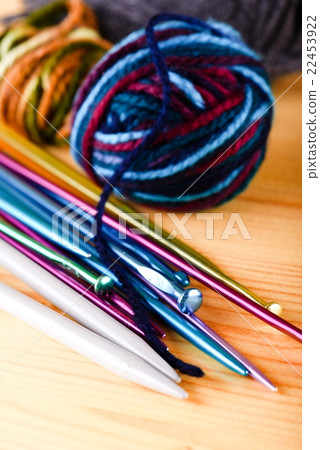 Several color knitting needles with balls of wool 22453922