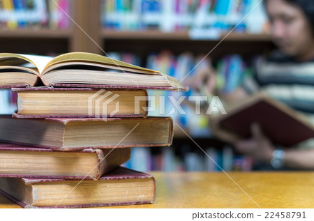 old book on the desk in library with the man reading the book background old book on the desk in library with the man reading the book background 22458791