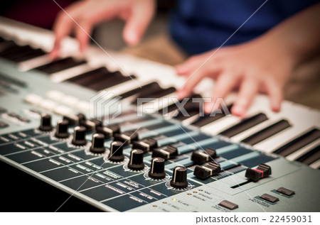 closeup audio mixer on hands playing the keyboard background,vintage color tone 22459031