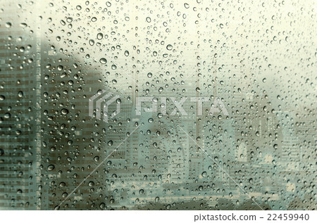 Waterdrops on a glass surface windows with closeup cityscape background 22459940
