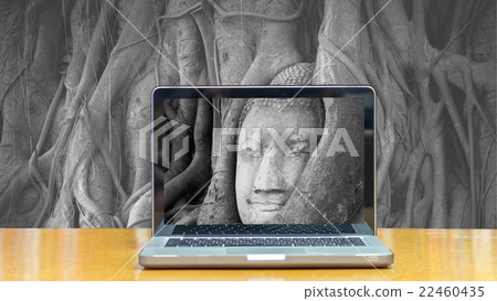 Conceptual image of a computer laptop on Head of sand stone buddha in a tree at Wat Mahathat, Ayutthaya, Thailand, public temple 22460435