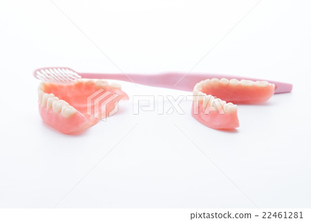 Acrylic dentures with toothbrush on white 22461281