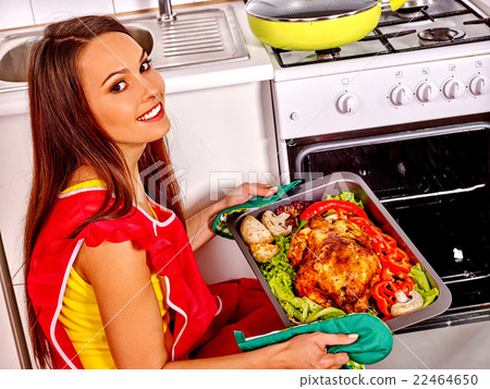 Woman cooking chicken at kitchen. 22464650