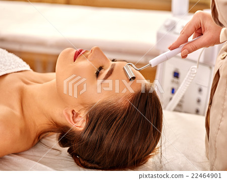 Young woman receiving electric facial massage. Young woman receiving electric facial massage. 22464901