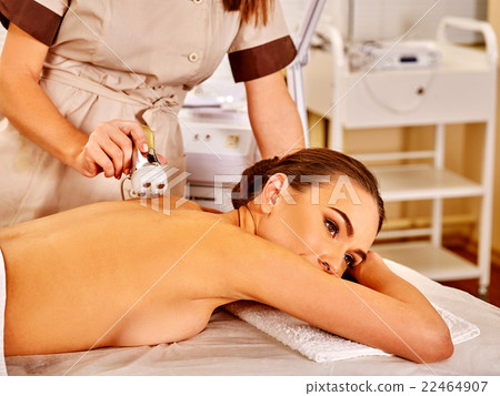 Young woman receiving electric back massage. 22464907